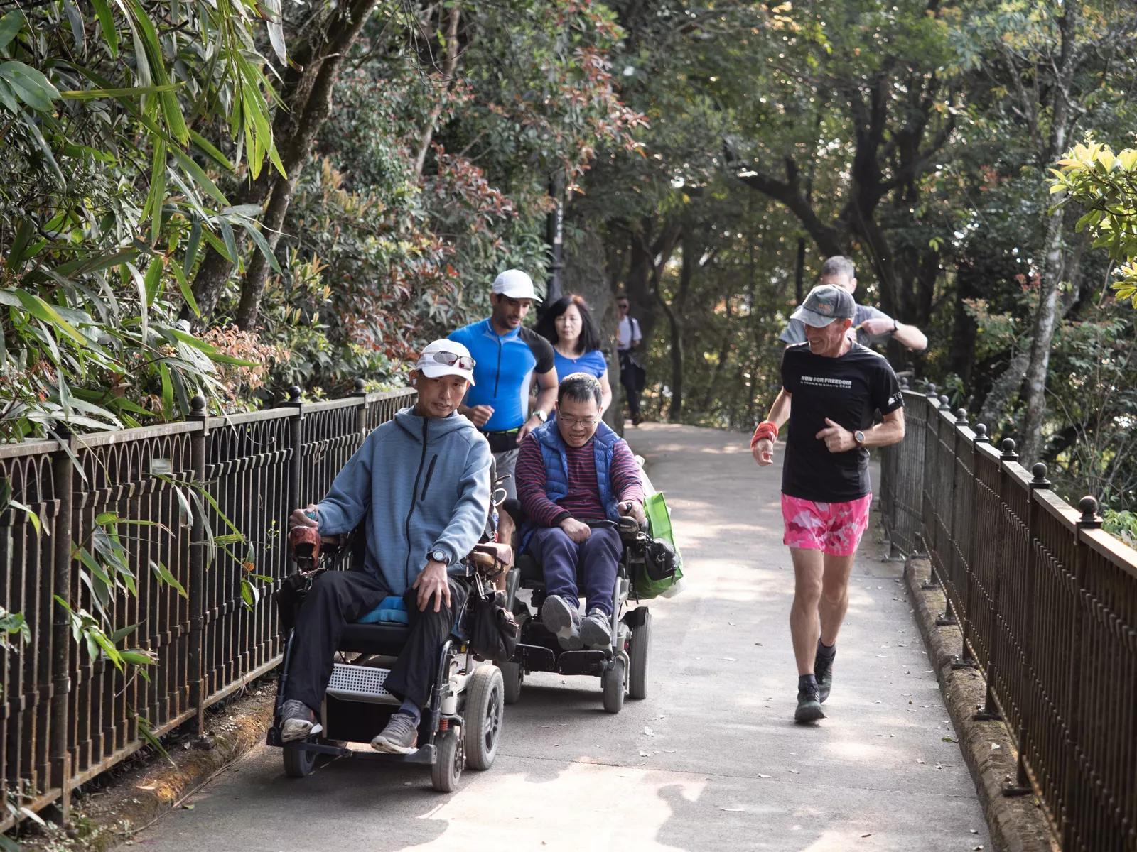 Jo Lodder runs alongside adaptive athletes in electric wheelchairs, promoting inclusion